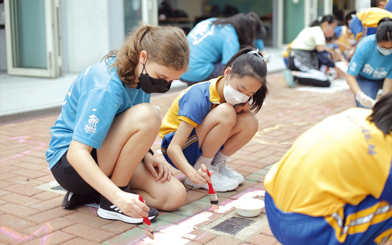 Last year, the English subject team also cooperated with the charity organization "Hong Kong Habitat for Humanity" to organize the "Colorful Campus Art Project", inviting 40 foreign and local volunteers to the school to work with the students in painting a 17-meter-long large-scale painting with "Value our variety" and "Strength with Actions" in the school's open square to express the school's teaching philosophy of cultivating students' diverse development and value education.